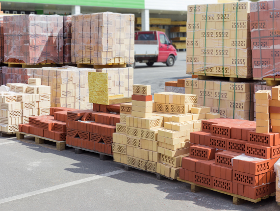 Pallets of perforated red and yellow bricks on warehouse